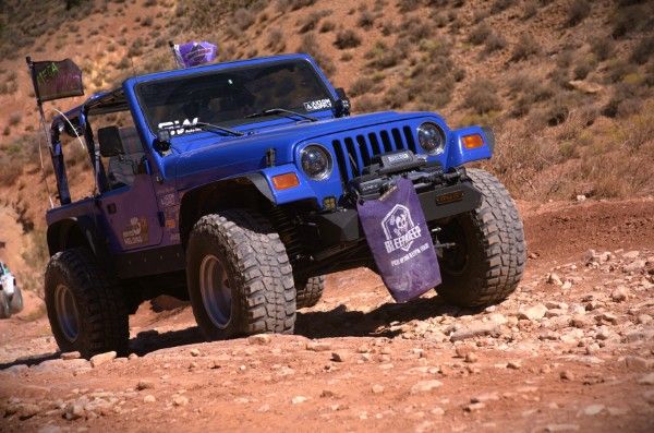 Wyatt's blue 1997 Jeep Wrangler, Betty Lou, with a front winch bumper and big off-road tires on a rocky red-dirt trail